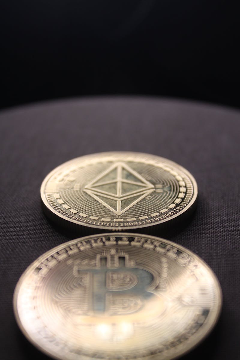 Detailed shot of Bitcoin and Ethereum coins on a dark surface.
