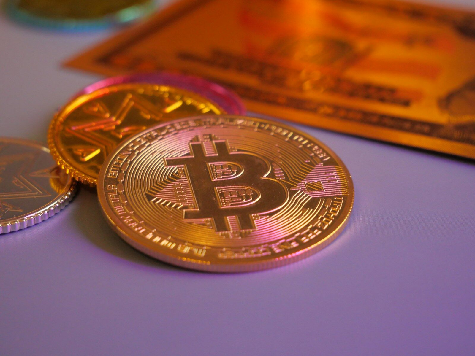 Golden bitcoin coin with other coins and card.